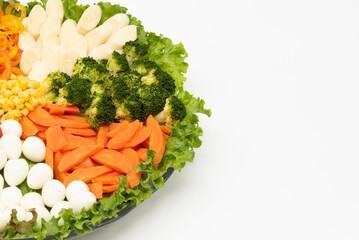 Delicious and healthy lettuce salad with various vegetables and quail egg isolated on white background with copy space