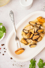 Plate with pickled mussels on white background