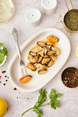 Plate with pickled mussels on white background