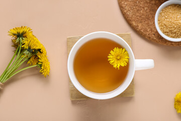 Cup of healthy dandelion tea on beige background