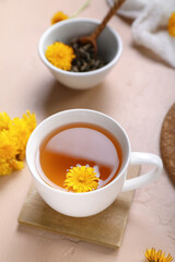 Cup of healthy dandelion tea on beige background