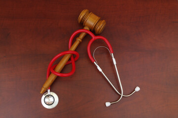 Laws and medicine concept. Judge gavel and stethoscope on table.