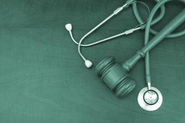 Judge gavel with stethoscope on wooden table. Malpractice and forensic concept.