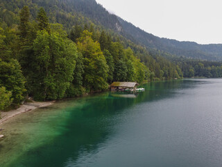 Fototapeta na wymiar German wooden summer house overlooking scenic lake at mountains. Bavarian Alps.