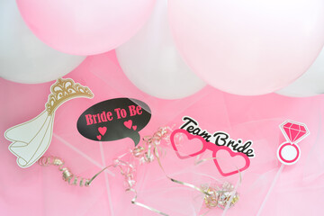 Bachelorette party favors on pink background with balloons