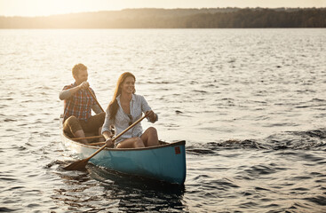Boat ride and sunshine. a young couple rowing a boat out on the lake.