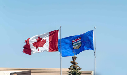 A waving Canada and Alberta flag on a windy day.