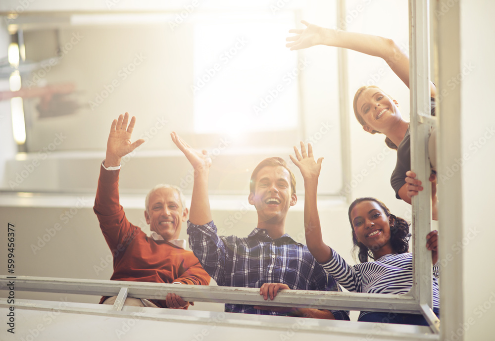 Poster Hi form the top. Portrait of a group of smiling coworkers waving at the camera while standing in a stairwell.
