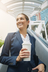 Coffee completes her commute. a young businesswoman drinking a coffee on her way to work.