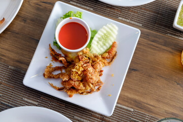 Deep-Fried Soft Shell Crab on Elegant Plate Served with hot sauce side view camera angle