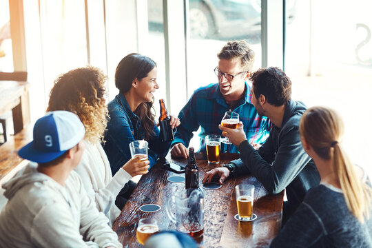 Their go to spot for good times. a group of friends enjoying some beers at a bar.