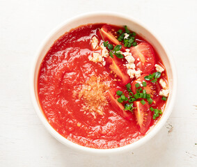 Tomato soup on white table, top view