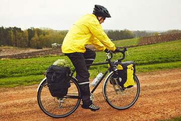 Fototapeta premium He spends his free time on the road. Full length shot of a male cyclist enjoying a bike ride on a wet winters morning.