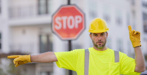 Builder with stop road sign. Builder with stop gesture, no hand, dangerous on building concept. Man...
