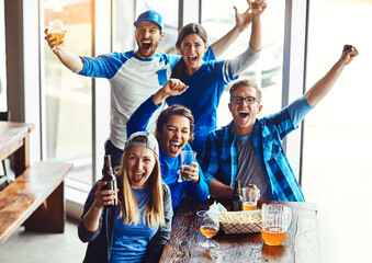 And theyve scored. a group of friends cheering while watching a sports game at a bar.