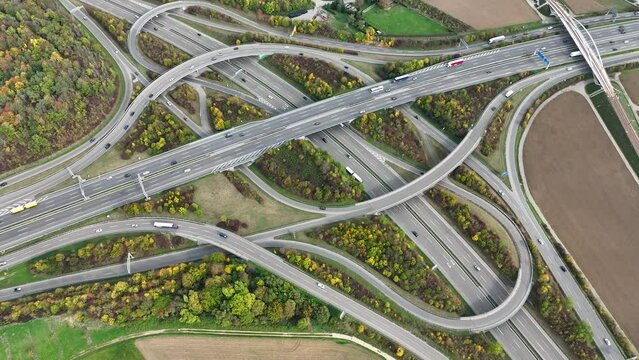 Aerial drone view of a multi-level highway intersection with moving cars near the city of Stuttgart, Germany. Trucks move along a multi-level road junction. The concept of the urban.