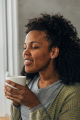 A beautiful Multiracial woman enjoys her coffee in the morning.