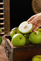 Green apples in a basket, fresh apples (scene inside the orchard)