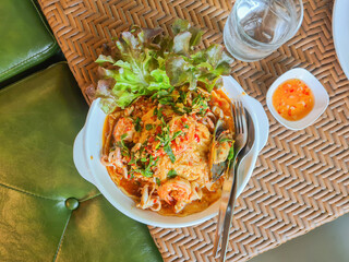 Omelet rice with seafood basil sauce, decorated with fresh vegetables