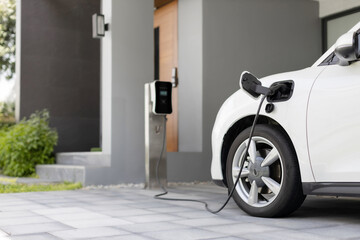 Fototapeta na wymiar Progressive concept of EV car and home charging station powered by sustainable and clean energy with zero CO2 emission for green environmental. Charging point at residential area for electric vehicle.