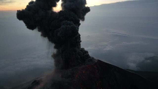 Volcan de Fuego in Guatemala aerial drone video of volcano erupting at dusk shooting smoke, ash and lava into the air 