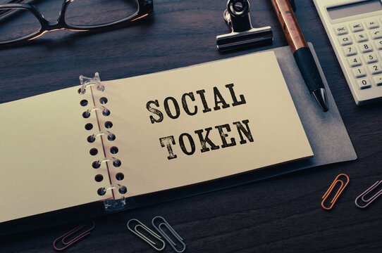 There is notebook with the word Social Token.It is as an eye-catching image.