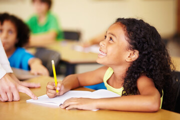 Teaching, child writing and hand of teacher helping student at school for education, learning or development. Woman with happy girl for notebook, pencil and knowledge at classroom desk with support