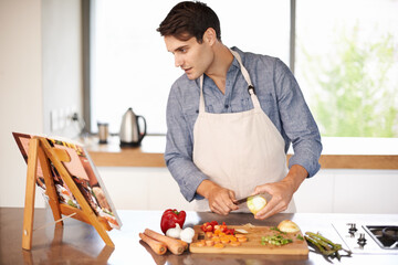 Cooking, man and cookbook in a kitchen with food, vegetables and ingredients for meal. Reading, male person and healthy diet in a house for nutrition eating and chef learning with a book and knife