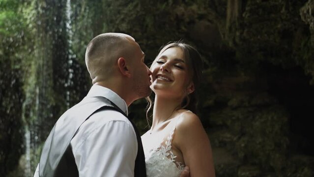 Young couple in love bride and groom, wedding day near a mountain waterfall. Enjoy a moment of happiness and love