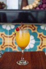 Glass of fresh Orange Juice with fresh fruits on wooden table with summer background.