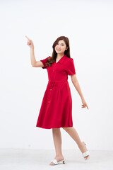 Portrait of a beautiful, charming lady wearing a red dress on a white background