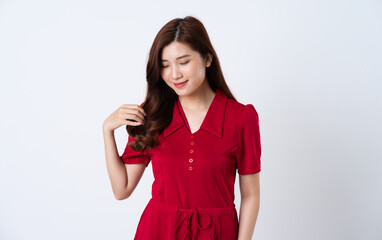 Portrait of a beautiful, charming lady wearing a red dress on a white background