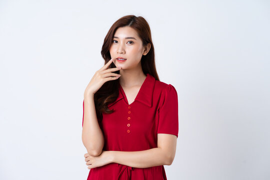 Portrait of a beautiful, charming lady wearing a red dress on a white background