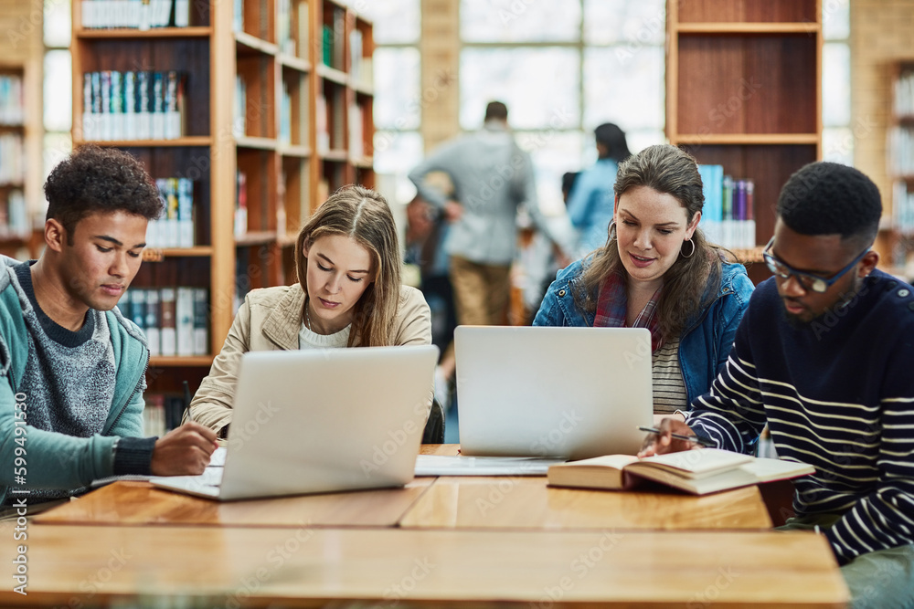 Poster staying fully engaged in their education. a group of university students working in the library at c