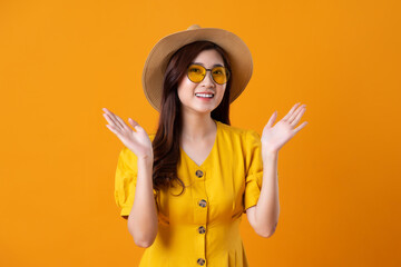 portrait of beautiful asian girl wearing yellow dress on orange background