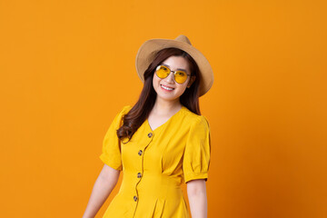 portrait of beautiful asian girl wearing yellow dress on orange background