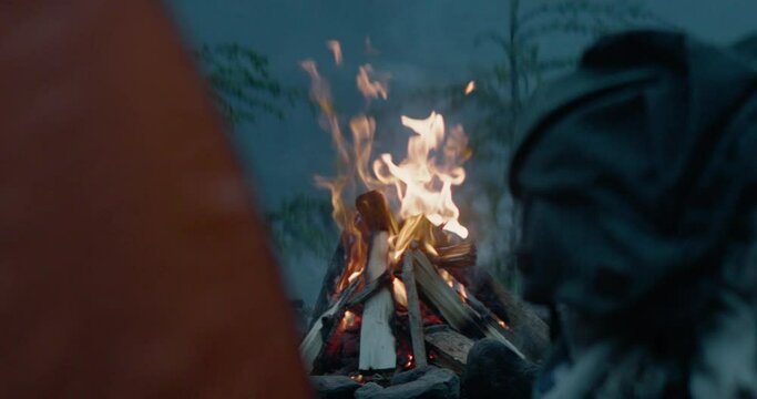 Campfire burning strong at dusk camping spot