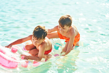 Two boys or brothers on mattress on Red Sea