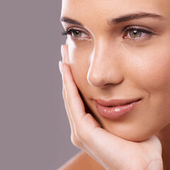 Seeing her beauty close up. Beauty shot of a beautiful young woman with perfect skin against a gray background.