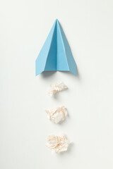 Paper plane and paper balls on white background
