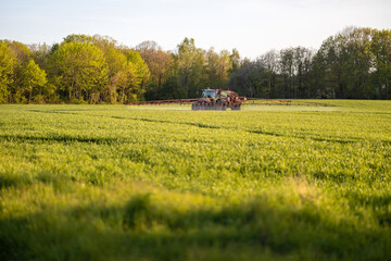 Traktor beim Feld abfahren mit einer Feldspritze und Pflanzenschutz