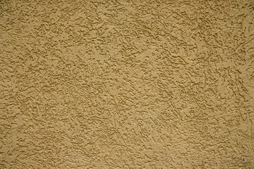 Pale yellow rough plastered house wall as texture, pattern, background