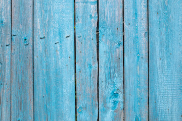 Antique plank wooden fence in blue color as a texture, background, pattern