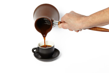 Man pouring coffee into cup isolated white background. Clay cezve for making coffee in the hand