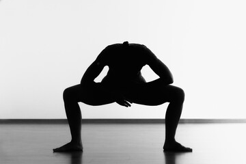 Silhouette of middle age sporty woman practicing yoga at studio. Black and white photo isolated on white background
