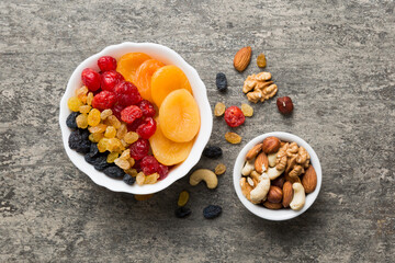 healthy snack: mixed nuts and dried fruits in bowl on table background, almond, pineapple, cranberry, cherry, apricot, cashew