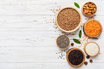 Various superfoods in smal bowl on colored background. Superfood as rice, chia, quinoa, lentils, nuts, sesame seeds, almonds. top view copy space