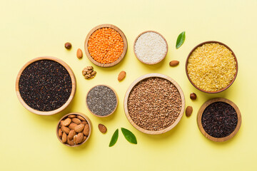Various superfoods in smal bowl on colored background. Superfood as rice, chia, quinoa, lentils, nuts, sesame seeds, almonds. top view copy space
