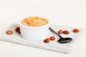 Bowl of peanut butter and peanuts on table background. top view with copy space. Creamy peanut pasta in small bowl