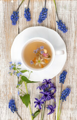 Tea Time: Relaxing with herbal tea with healing properties. Drink with natural herbs. Floral tea arrangement. Nature's remedy aromatic herbal tea with healing herbs and flowers top view vertical